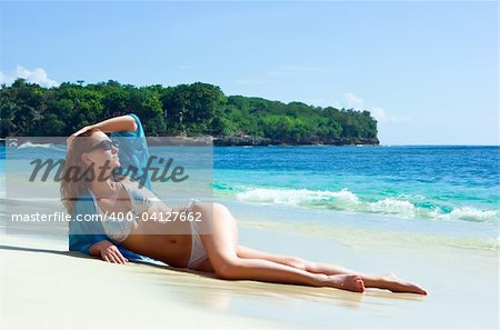 Belle brune jeune fille relaxante sur la plage de sable sur l'île de Bali en Indonésie