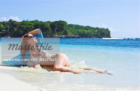 Beautiful brunette young girl relaxing on the sand beach on Bali island in Indonesia