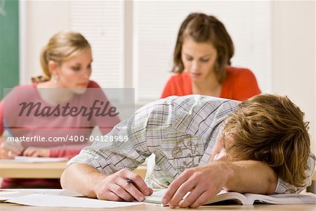 Student sleeping at desk in classroom