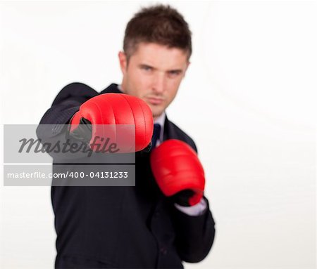 Jeune homme d'affaires attrayant avec des gants de boxe et de se concentrer sur les gants