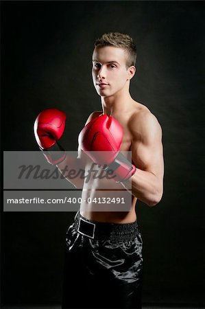 Young  shaped man boxing, isolated studio shot