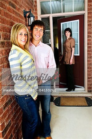 Real estate agent with couple welcoming to new home