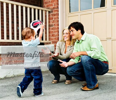 Heureux jeune famille, jouer au soccer avec enfant en bas âge sur la voie d'accès