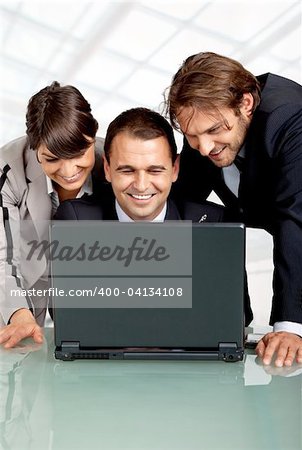 three happy businesspeople with a laptop, laughing