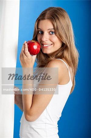 Portrait de douce et belle jeune femme tenant une pomme rouge