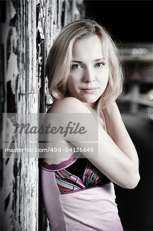 Young Pretty Woman Against Grunge Wall With Old Posters