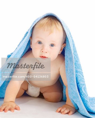 Bébé surprise sous la serviette de bain bleu