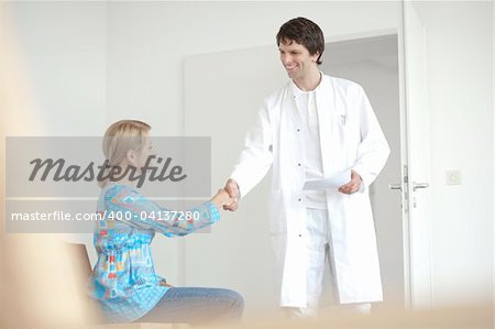 Doctor and patient, in waiting room, greetings and welcome smiling doctor