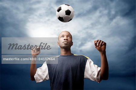afrcican soccer player heading a ball in a stormy weather