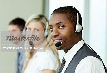Geschäftsleute mit Headsets lächelnd in die Kamera bei der Arbeit