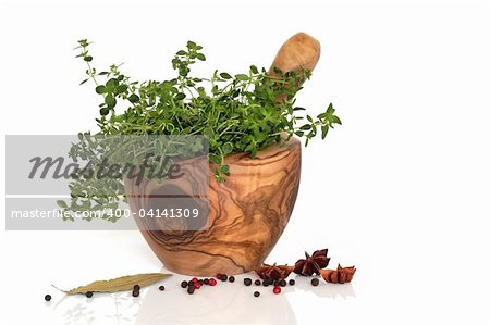 Thymian-Kraut bewirkt eine Olive Holz Mörser und Pistill mit Sternanis würzen, Pfeffer und einem Lorbeerblatt over white Background.