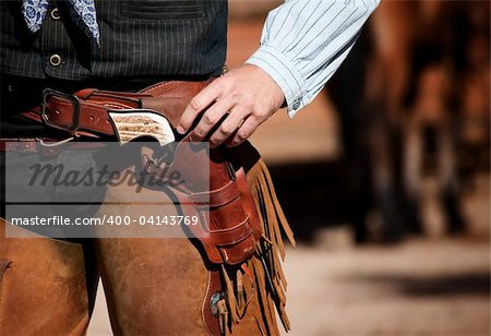 Closeup of cowboy with chaps, gun and leather belt