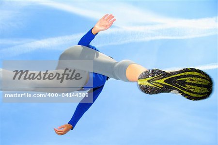 Running and jumping over the camera. Speed and action composition. Shallow depth of field, focus on the female running shoe.