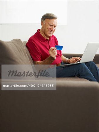 senior man with laptop computer and credit card. Copy space