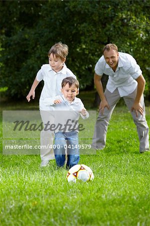 Competition of two little brothers in football in a summer garden