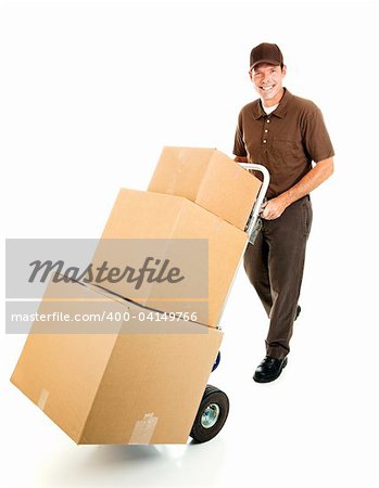 Friendly delivery man or mover pushes a stack of boxes on a hand truck.  Full body isolated.