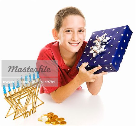 Adorable little boy with a Chanukah gift, menorah, dreidel and gelt.  Isolated on white.