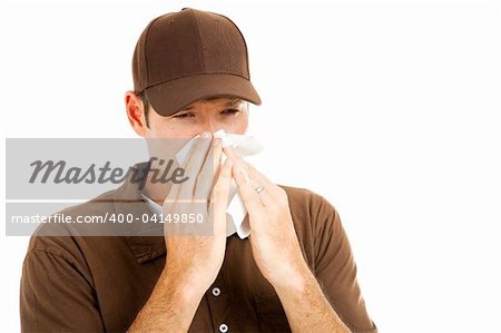 Delivery man at work, blowing his nose in a tissue.  Isolated on white.