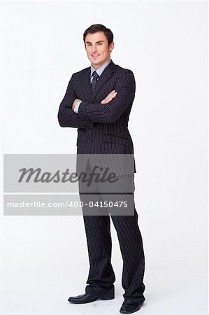 Confident young businessman with folded arms against white