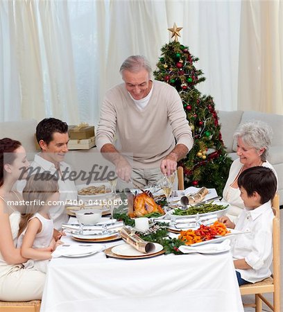 Happy family celebrating Christmas dinner with turkey at home