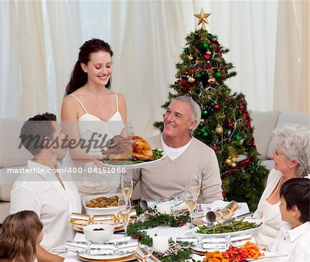 Woman showing turkey to her family for Christmas dinner