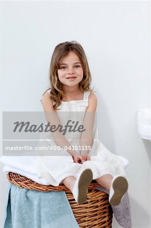 Little girl sitting in bathroom smiling at the camera