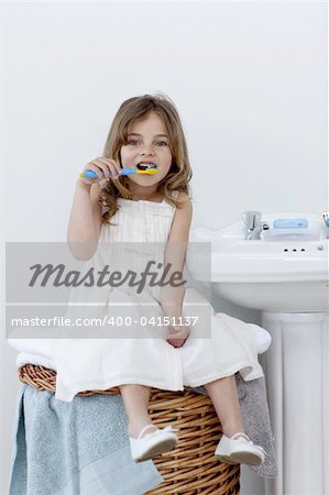 Beautiful daughter cleaning her teeth in bathroom