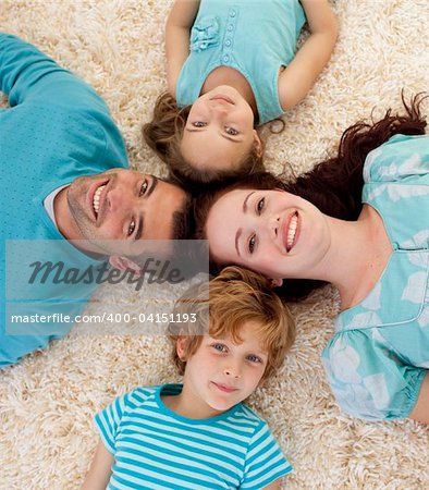 Happy young family on floor with heads together
