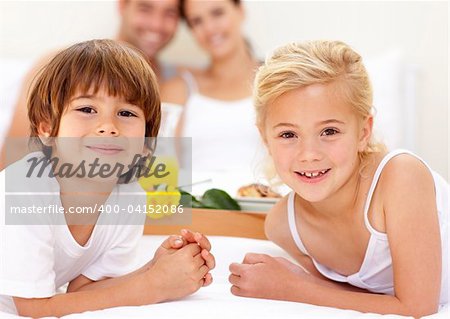 Portrait of children in bed with their parents after having breakfast