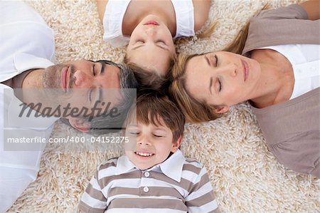 Tired family lying on floor with heads together