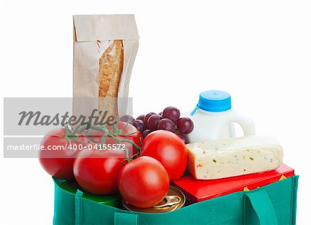 Closeup of groceries in a eco-friendly, reusable, green cloth bag.  Shot on white background.