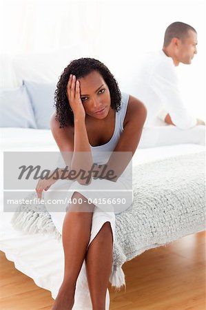 Upset couple sitting on the bed after having an argument