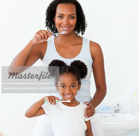 Mother and her daughter brushing their teeth in the bathroom