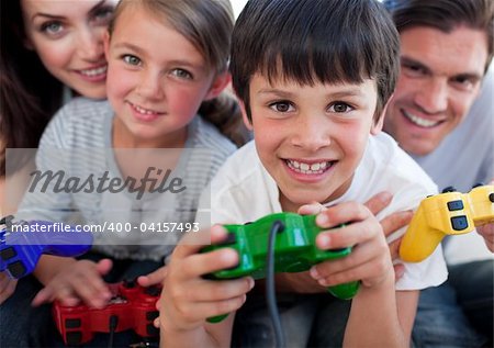 Happy parents and their children playing video games at home