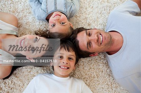 Happy family lying on the floor with heads together