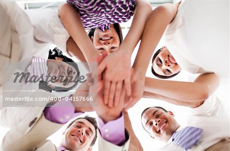 Smiling business people holding hands together in a circle against white background