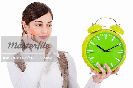 young beautiful brunette holding the clock and seeing on isolated white background