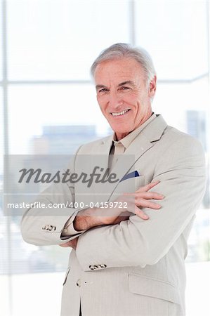 Attractive senior businessman with folded arms in a business building