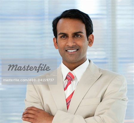 Smiling businessman with folded arms in a business building