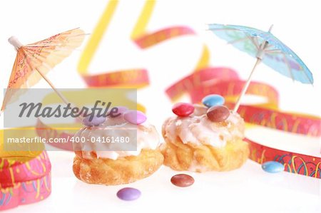 Two friedcakes with candies and ribbon on white background