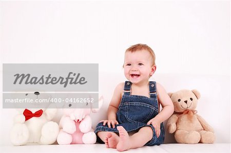 Portrait of cute laughing baby with plush toys