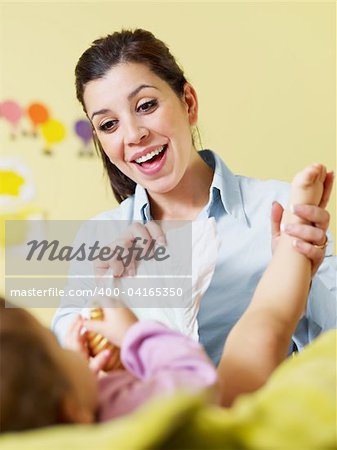 mom holding her daughter and changing diaper. Vertical shape, Copy space