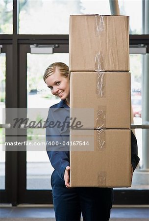 Young man delivering boxes.  Vertically framed shot.