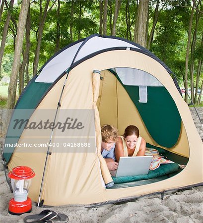 Couple in tent using laptop