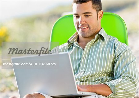 Man using laptop at beach