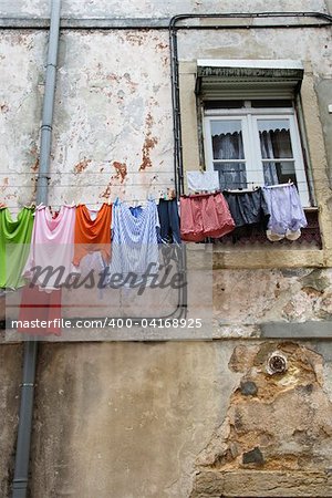 Laundry hanging from an upper story clothesline on an old building in Lisbon, Portugal. Vertical shot.