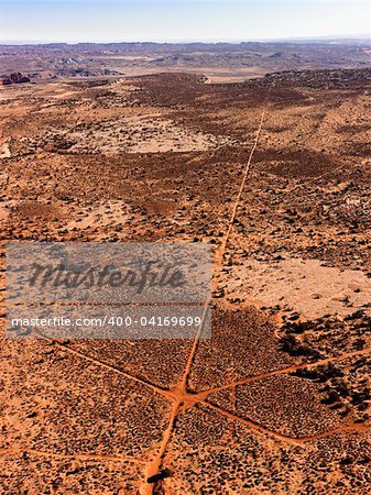 Aerial of intersecting dirt roads in a desert landscape. Vertical shot.