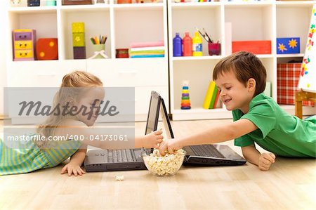 Kids with laptops eating popcorn in their room