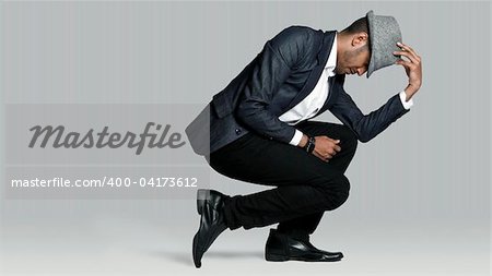 Man poses on one knee in studio