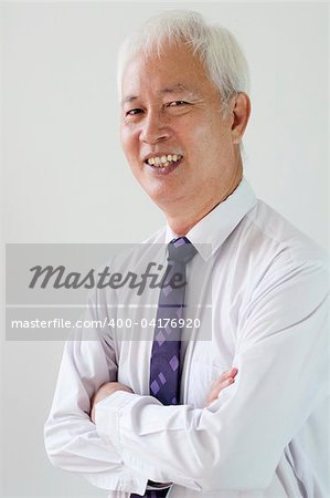 a smiling old asian ethnic businessman with plain background